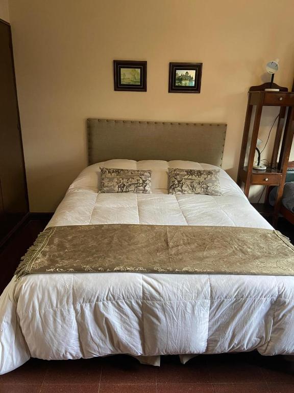 een groot wit bed met twee kussens erop bij Hotel Casa del Peregrino in Salta