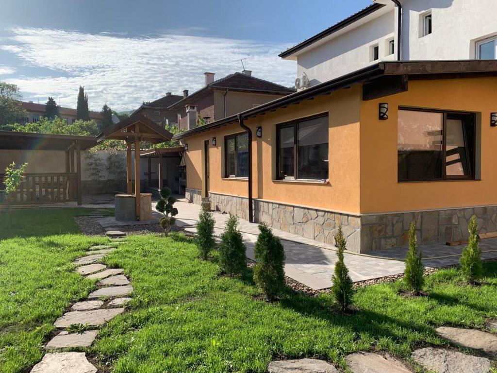 a house with a stone walkway next to a yard at Пътепис in Bratsigovo