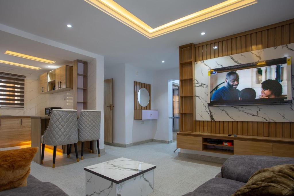 a living room with a tv on a wall at Love Square Platinum in Ilora