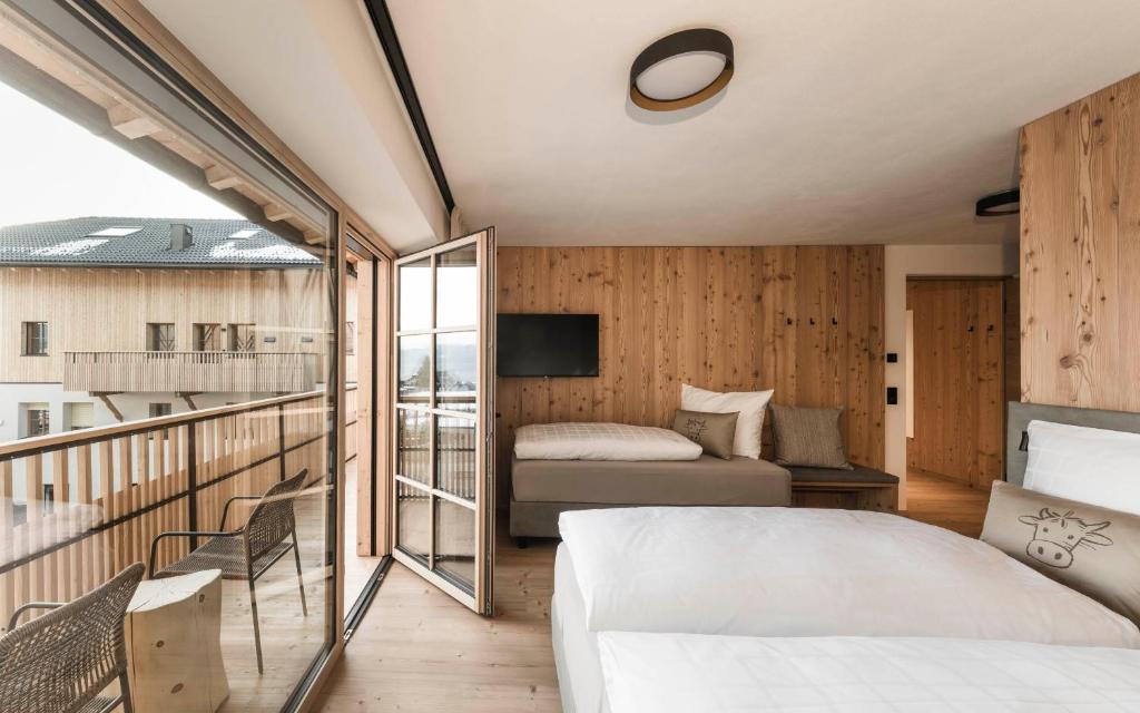een slaapkamer met een bed en een balkon bij Wieserhof Family Farm in Maranza