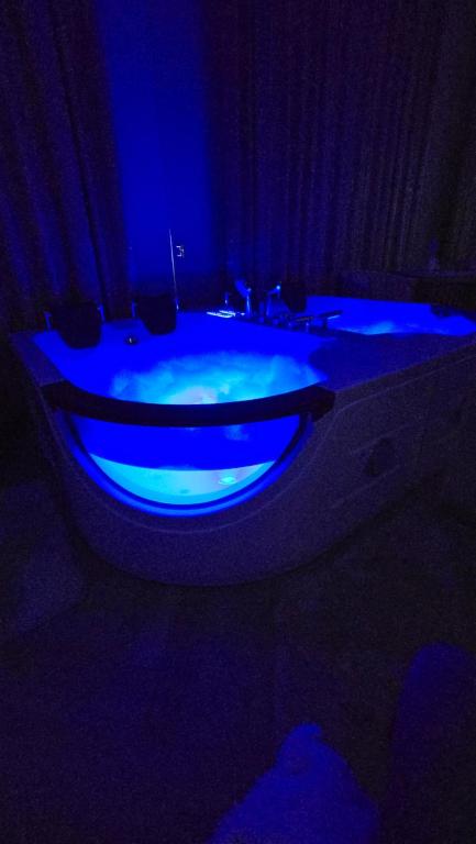 a blue bath tub with a sink in a dark room at Delux Apartament z jacuzzi in Pszczyna