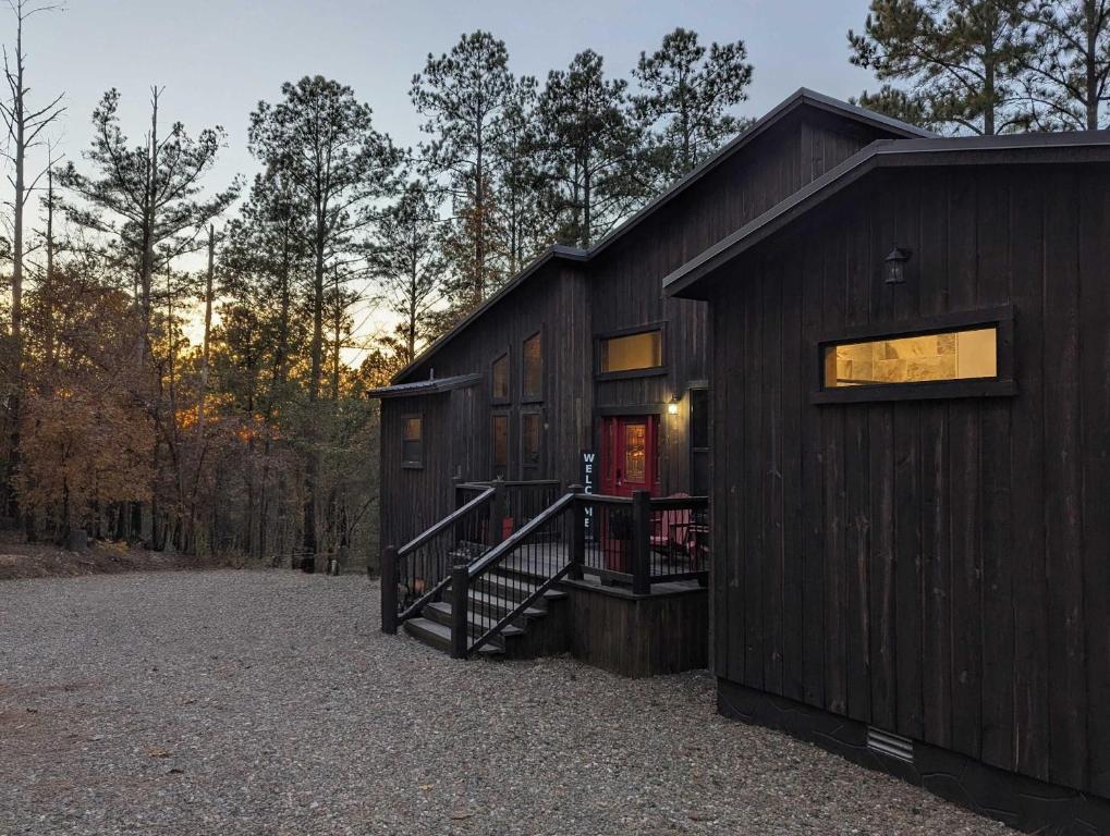 a black cabin with a staircase in the side of it at Serene mountain cabin with hot tub and 2 ensuites in Stephens Gap