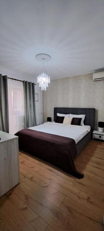 a bedroom with a large bed and a chandelier at Relax Apartament in Constanţa