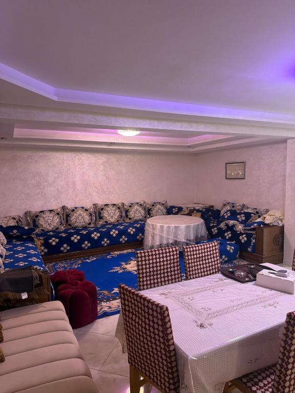a dining room with tables and chairs and a couch at Saad's villa in Mohammedia
