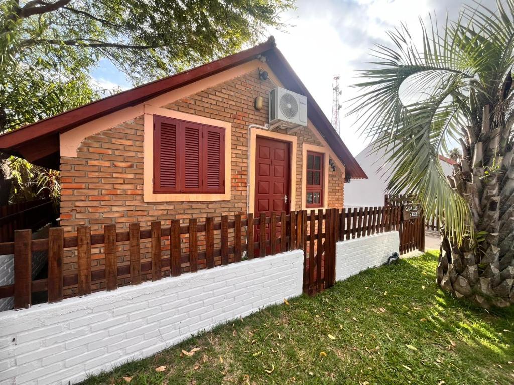een klein huis met een hek ervoor bij Cabañas Brisa's in Santa Vitória do Palmar