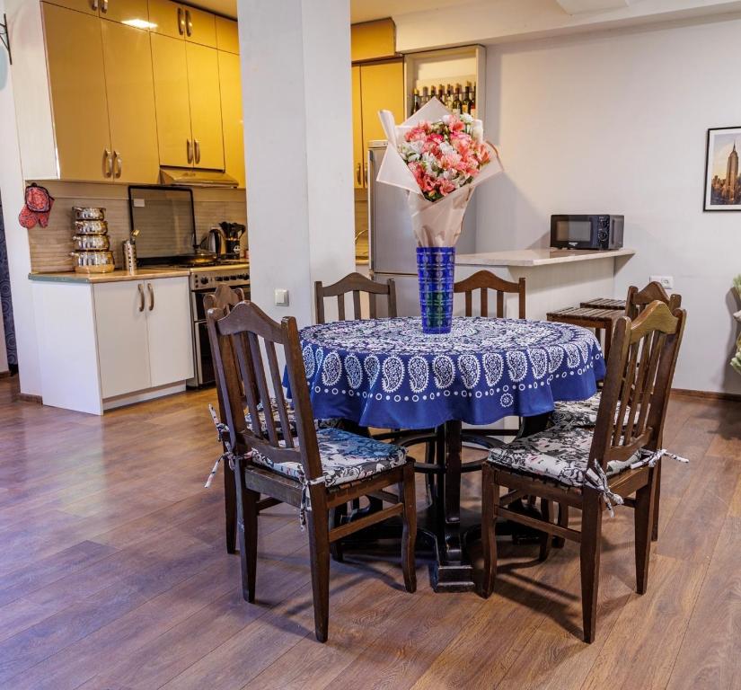 a dining room table with a vase of flowers on it at Only Flowers Girls Hostel in Tbilisi City
