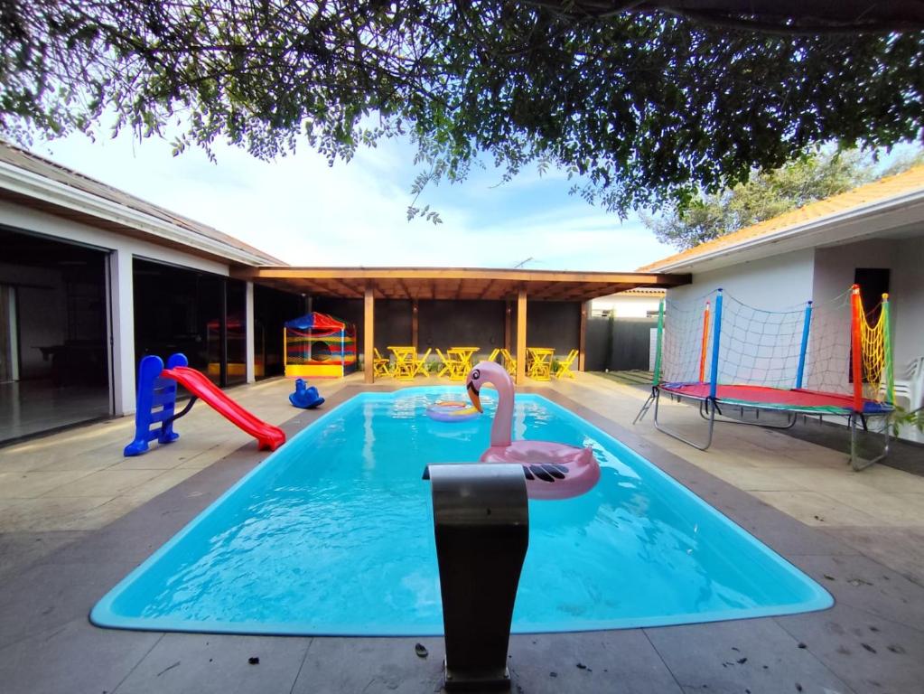 a swimming pool with a playground and a parking meter at Casa de 3 quartos com piscina in Laranjeiras do Sul