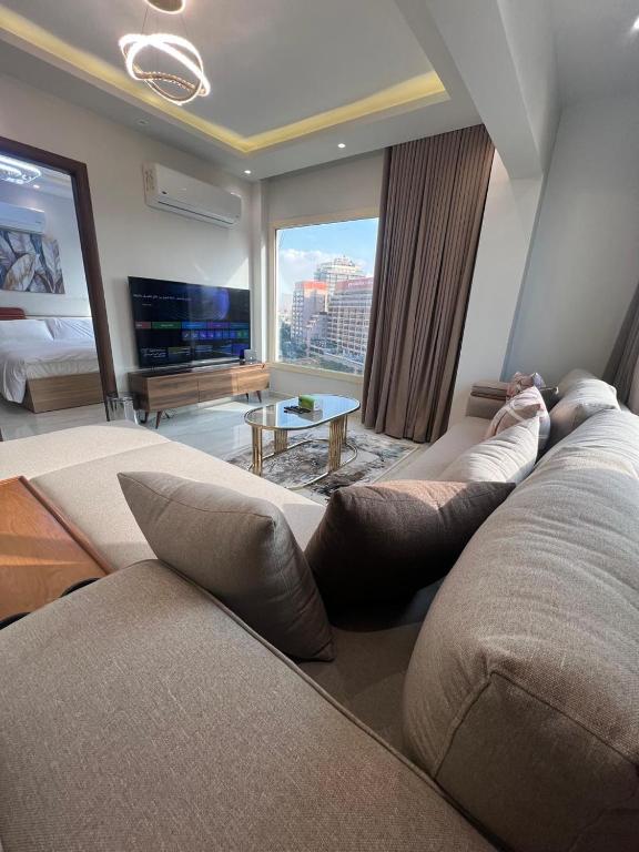 a living room with a couch and a large window at Doki sky suite in Cairo