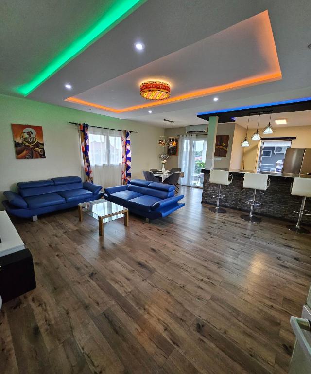 a large living room with blue couches and a table at Blue sky in Komé