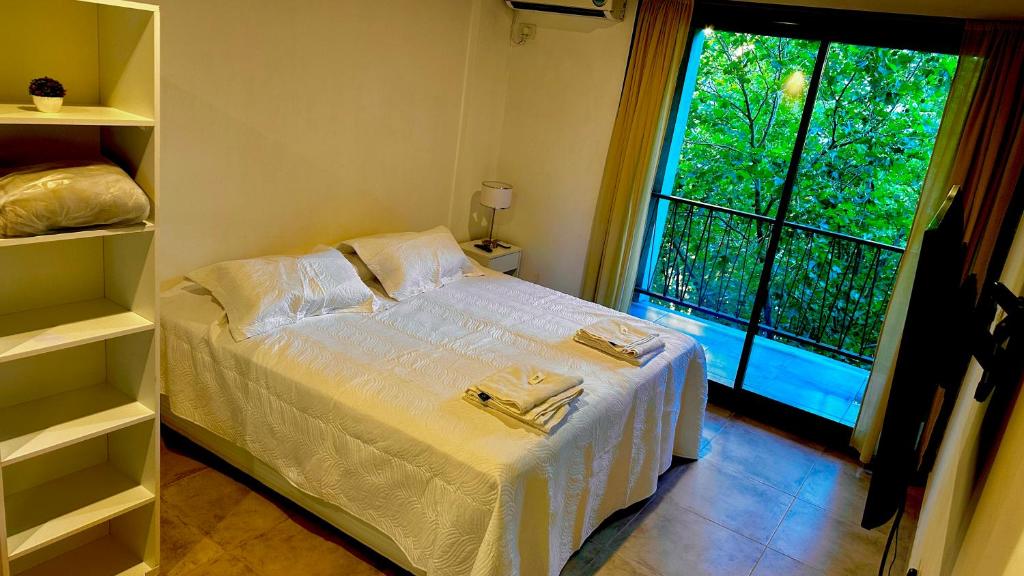 a small bedroom with a bed and a window at Studio 44 Escobar in Belén de Escobar