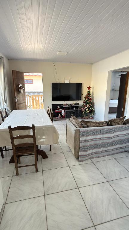 a living room with a table and a christmas tree at Bruna in Florianópolis