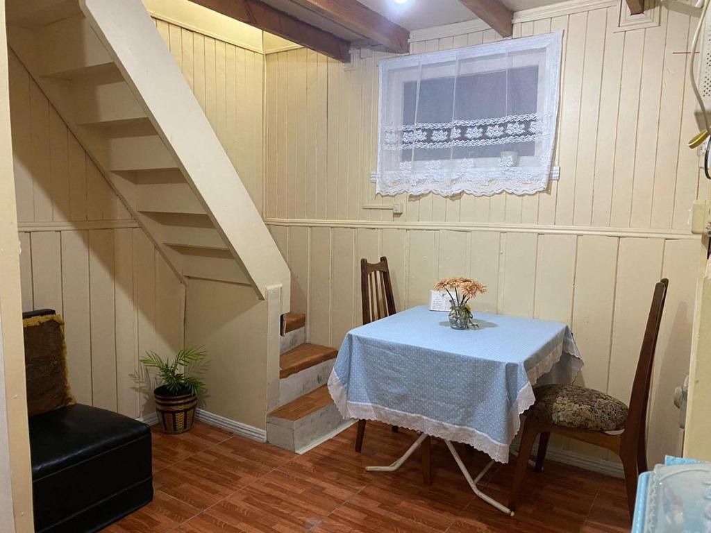 a dining room with a table and a staircase at Cabañas Casa Blanca in Valdivia