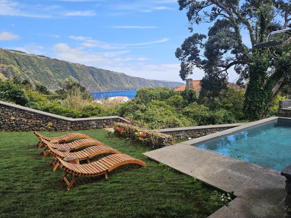 a group of chairs sitting next to a swimming pool at Blue Horizon Apartments in Varadouro