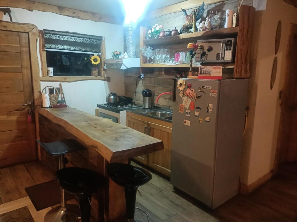 a kitchen with a refrigerator and a counter with stools at MyE in Frutillar