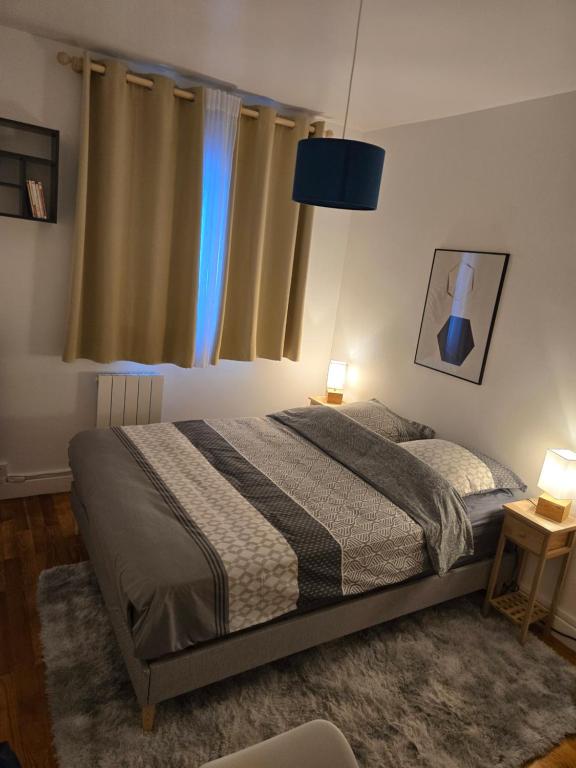 a bedroom with a bed and a blue lamp at Chambre idéalement située in Villeurbanne