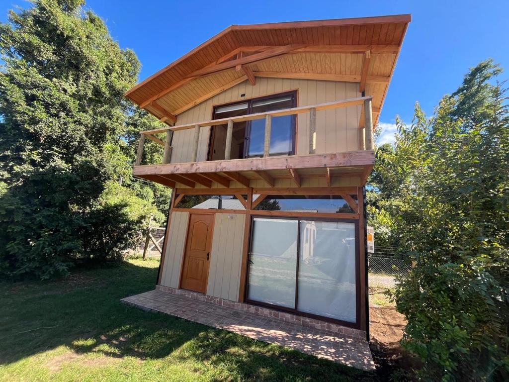 een huis met een veranda rondom en ramen bij cabañas walls 3 in Pucón