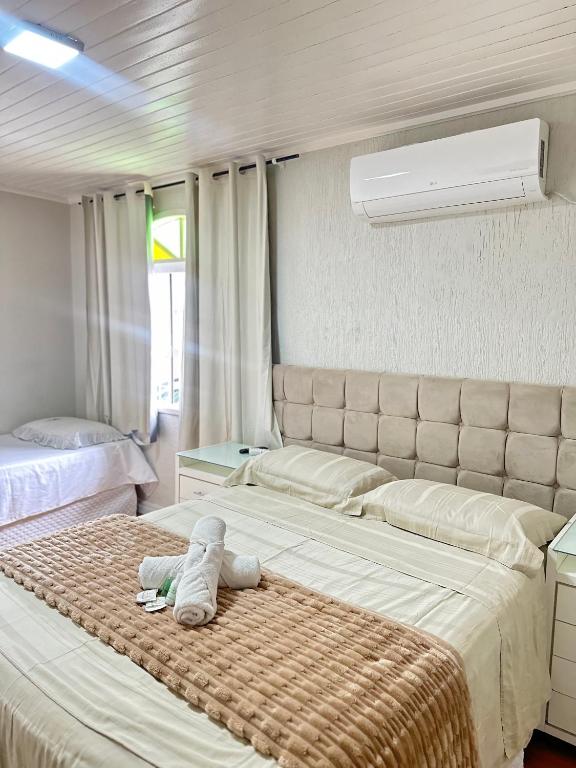 a bedroom with a bed with a stuffed animal on it at Suite em Hospedagem 100m da BR! in São José