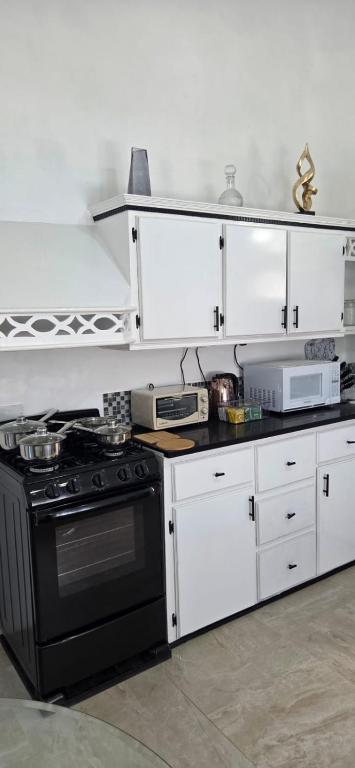 a kitchen with a black stove and white cabinets at Martha's House Kia in Soufrière