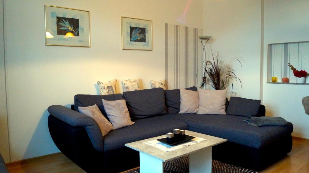 a living room with a blue couch and a table at Apartment 24 modern & gemütlich in Dessau