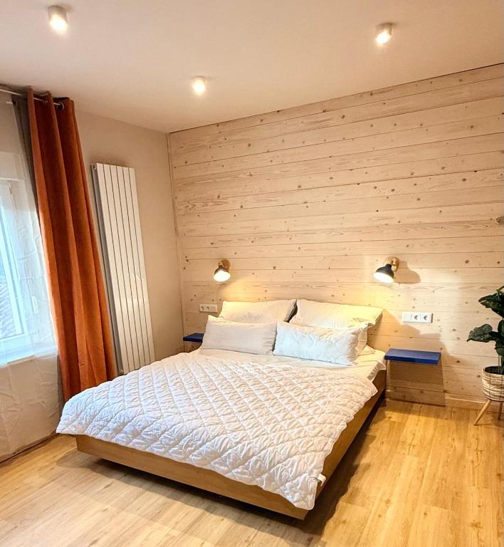 ein Schlafzimmer mit einem großen Bett und einer Holzwand in der Unterkunft Appartements am Radweg stille Pauline in Fehrbellin in Fehrbellin