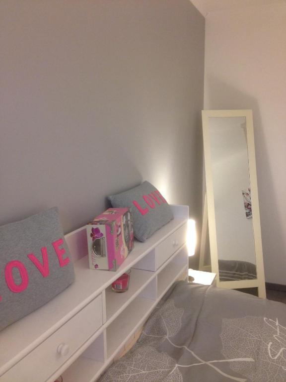 a bedroom with a white dresser and a mirror at Chez Laurence et Thomas in Cercié