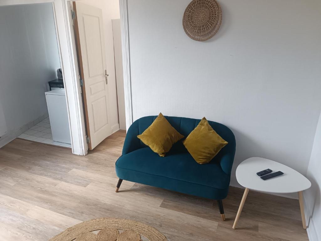 a blue couch with two yellow pillows in a living room at T2 Cosy 20 min Paris in Bezons