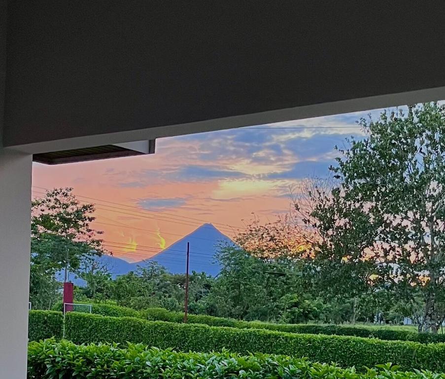 a view of a mountain through a window at Arenal Stone House in Ángeles