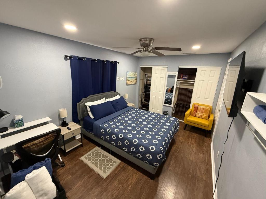 a bedroom with a blue bed and a desk at Signature Suite in Orlando