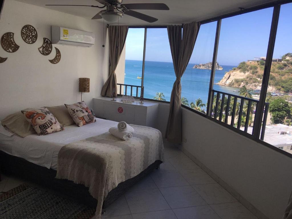 a bedroom with a bed with a view of the ocean at Apto Diners Rodadero WiFi - Piscina - Playa in Rodadero