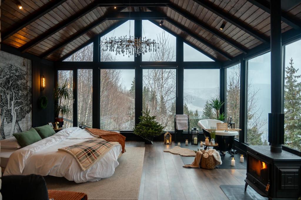 una camera da letto con un letto e una grande finestra di Noma Cabin a Măguri