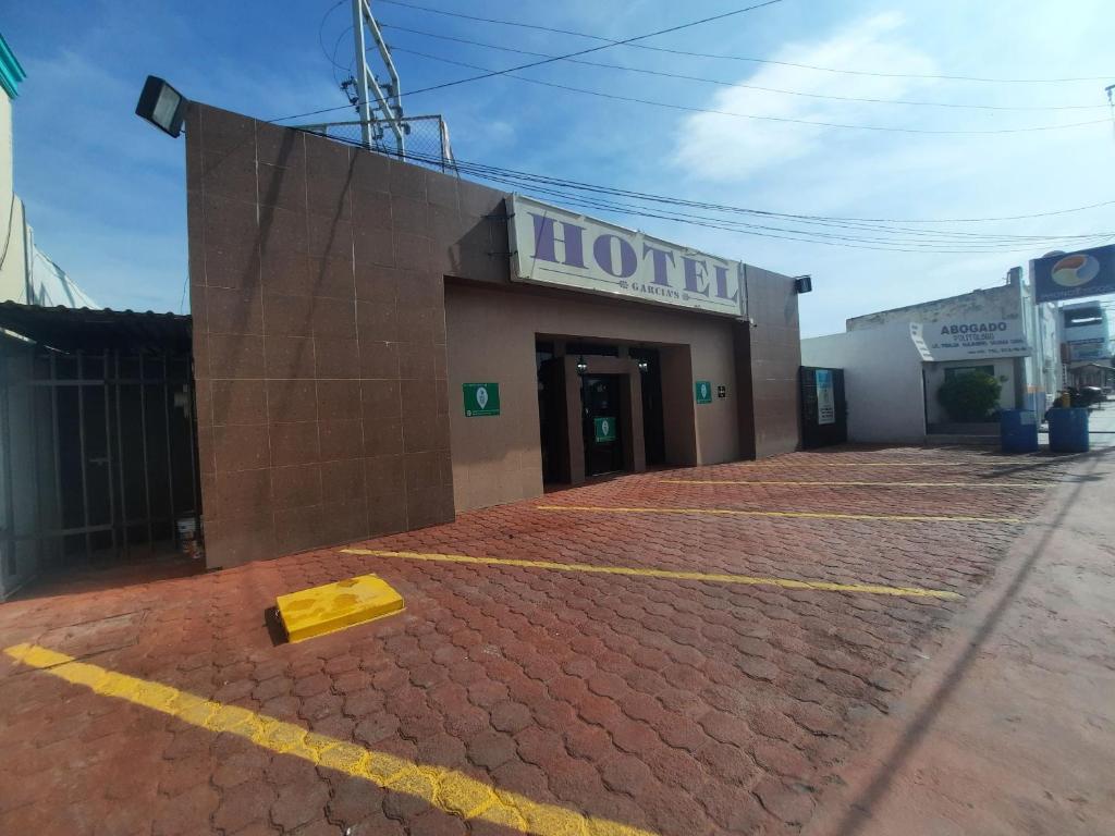 a hotel building with a yellow box on the ground at Garcia's Suites y Hotel Villegas in Linares