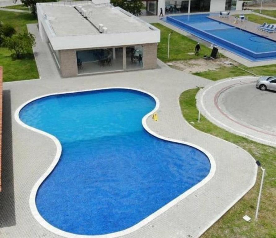 a swimming pool with blue water in front of a building at Park Cowboy - Valentina in João Pessoa