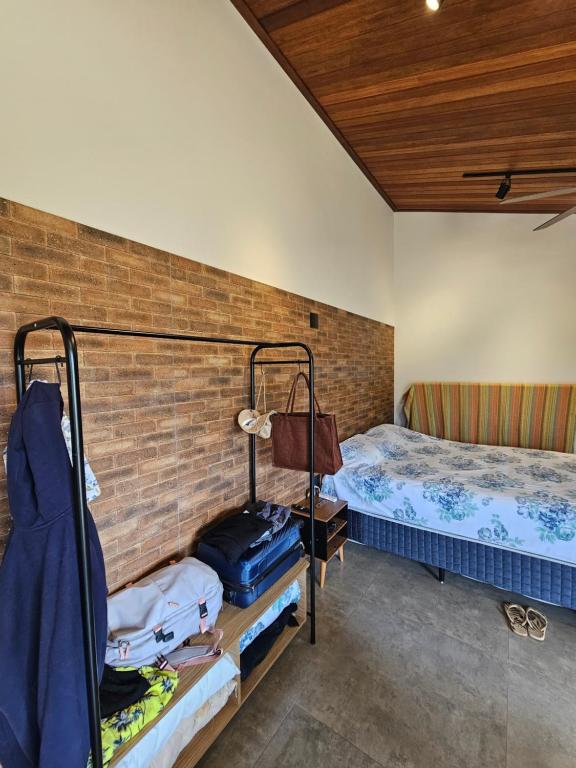 een slaapkamer met 2 stapelbedden en een bakstenen muur bij Chalé Curvas da Canastra in São Roque de Minas