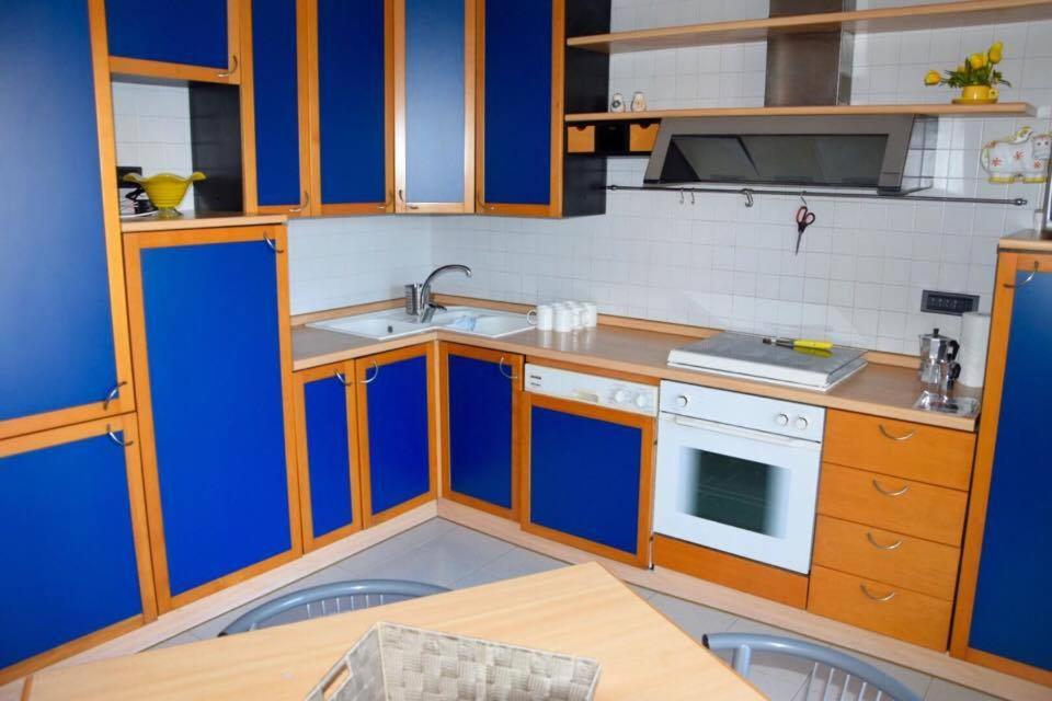 シラクーサにあるAppartamento C&Cのキッチン(青と白のキャビネット、テーブル付)
