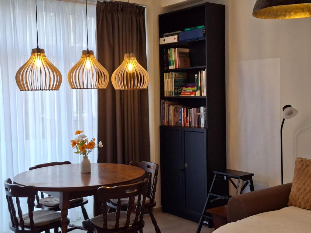 a living room with a table and a book shelf at Roosevelt Apartment Antwerp in Antwerp