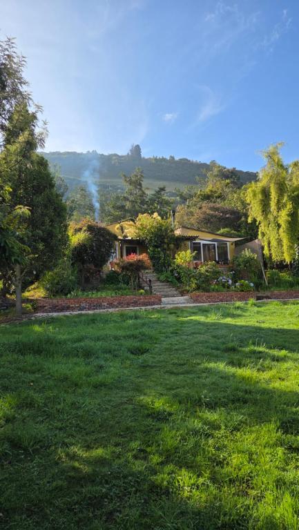 a group of houses in a field of grass at Finca Agrreste in Nemocón