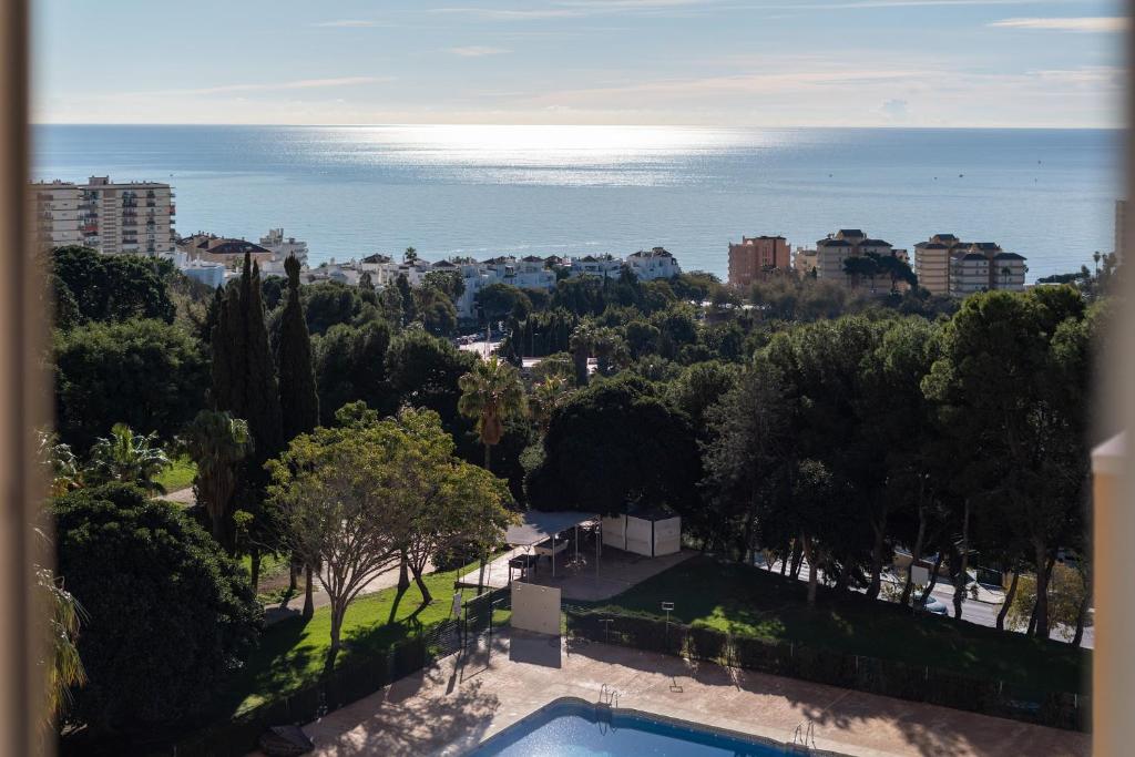 a view of a park with a swimming pool and the ocean at Increíble estudio boutique con vista al mar Mediterráneo in Benalmádena