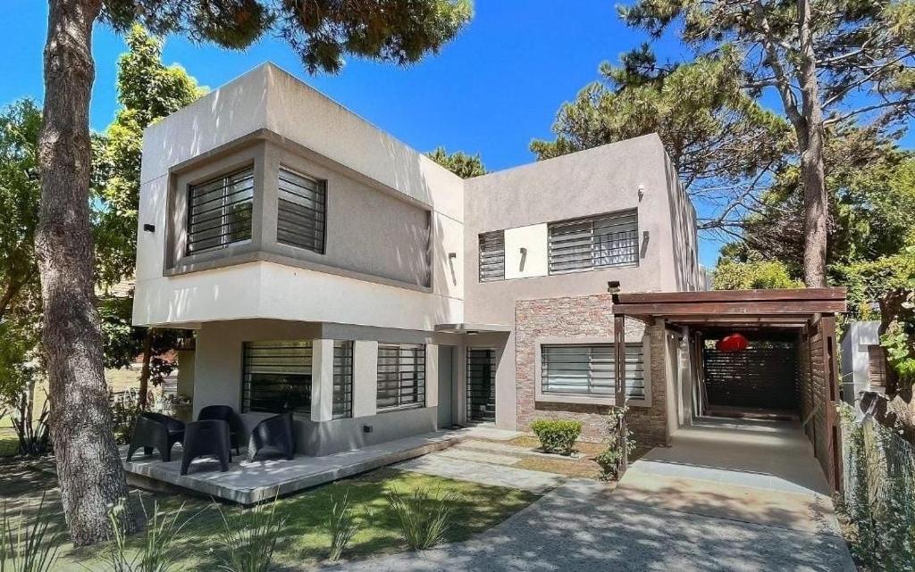 a large white house with trees in front of it at Casa Bouchard in Valeria del Mar
