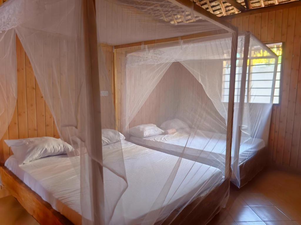 a bedroom with two bunk beds with mosquito nets at Sawa Sawa Beach Hotel&Backpacks in Malindi