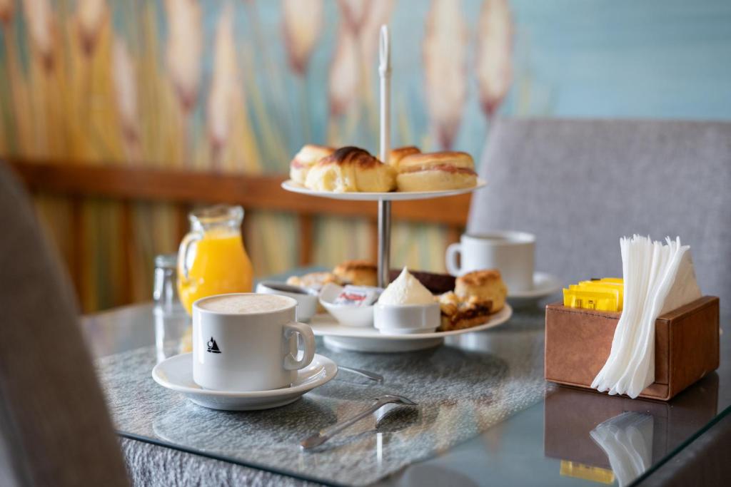 a table with two plates of pastries and coffee cups at Hostería Antu Kuyen in San Carlos de Bariloche