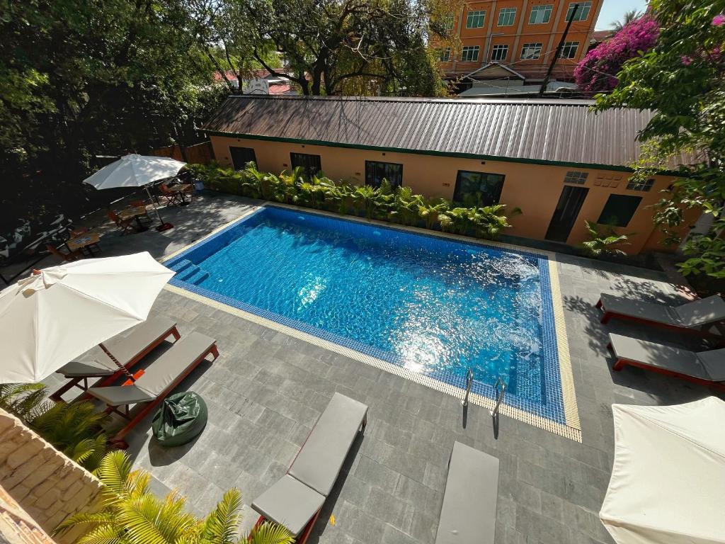 an overhead view of a swimming pool with chairs and umbrellas at Monkey Republic Kampot in Kampot