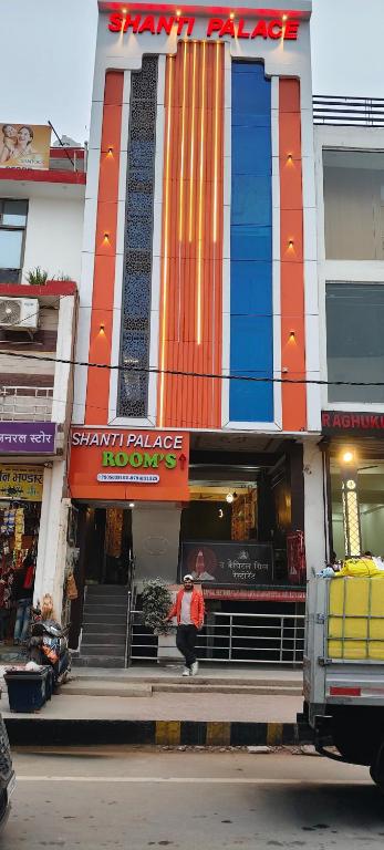 a woman walking in front of a building at Shanti palace and restaurant Ayodhya 1500 mtr Sri Ram Mandir ,near ayodhya dham railway station in Ayodhya
