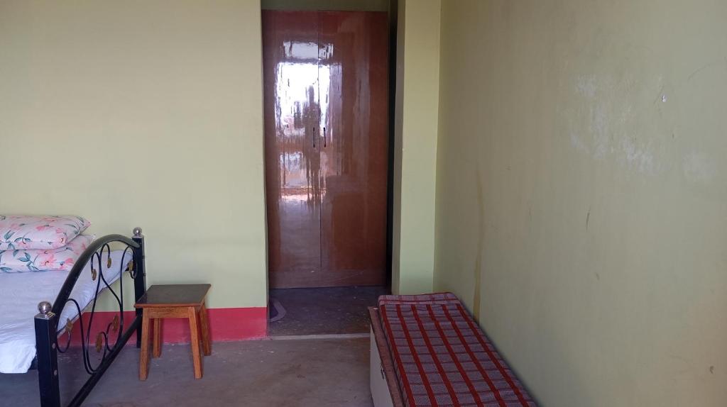 a room with a door and a bed and a stair case at K2k homestsy in Rhenok