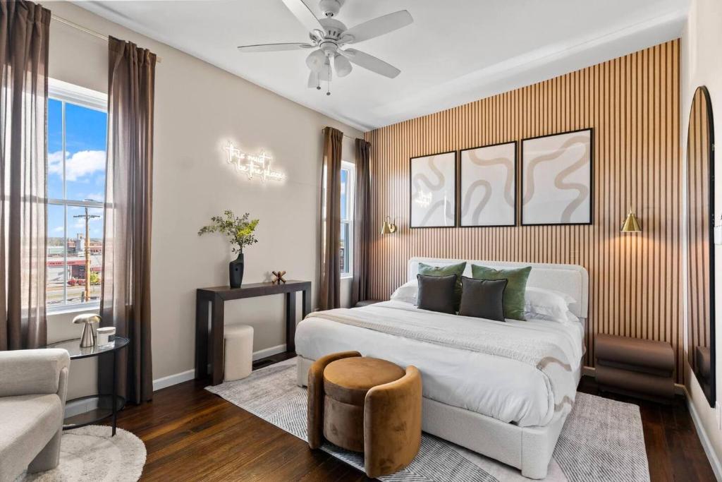 a bedroom with a large white bed and a chair at The Bricklight | Elevated 3BR + Parking in Soulard in Saint Louis