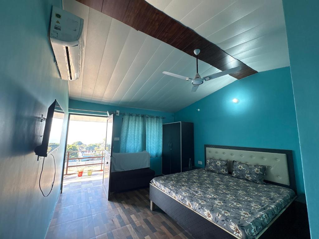 a bedroom with a bed and a ceiling fan at Rudraksh Hotel and restaurant in Amgarhi