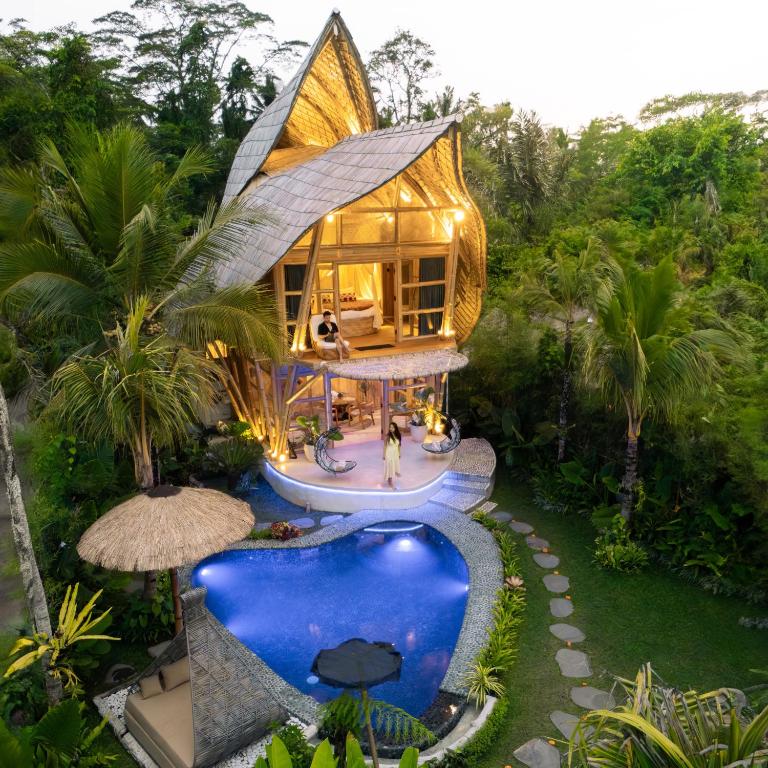 a house with a pool in the middle of a yard at Lazy Coconut Bali in Gianyar