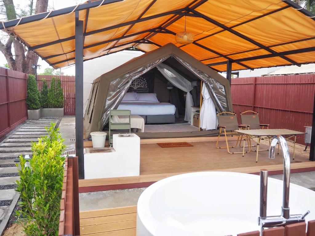 a tent with a bed and a table at Sichon Glamping Resort, Beachfront in Ban Plai Thon