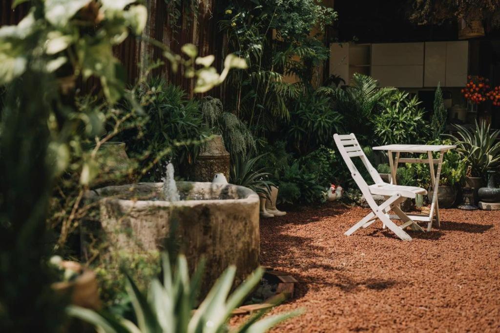 a white chair and a table in a garden at North House in Ấp Bình Trung