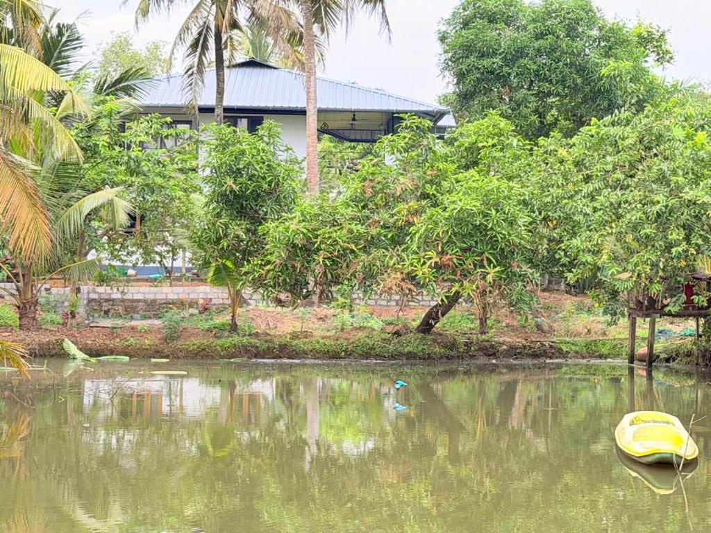 een gele boot in het water naast een huis bij Hestia Homestay in Kottayam