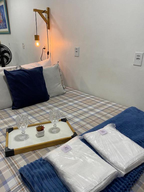 a bed with two glasses and a tray on it at Compact Studios Close to Shopping Centers, Downtown, Arena, Airport in Manaus